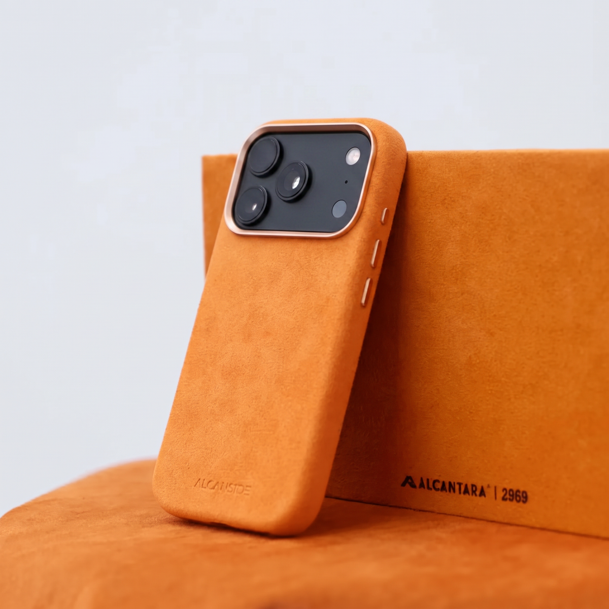 Orange Alcantara case for iPhone 18 Pro held in hands